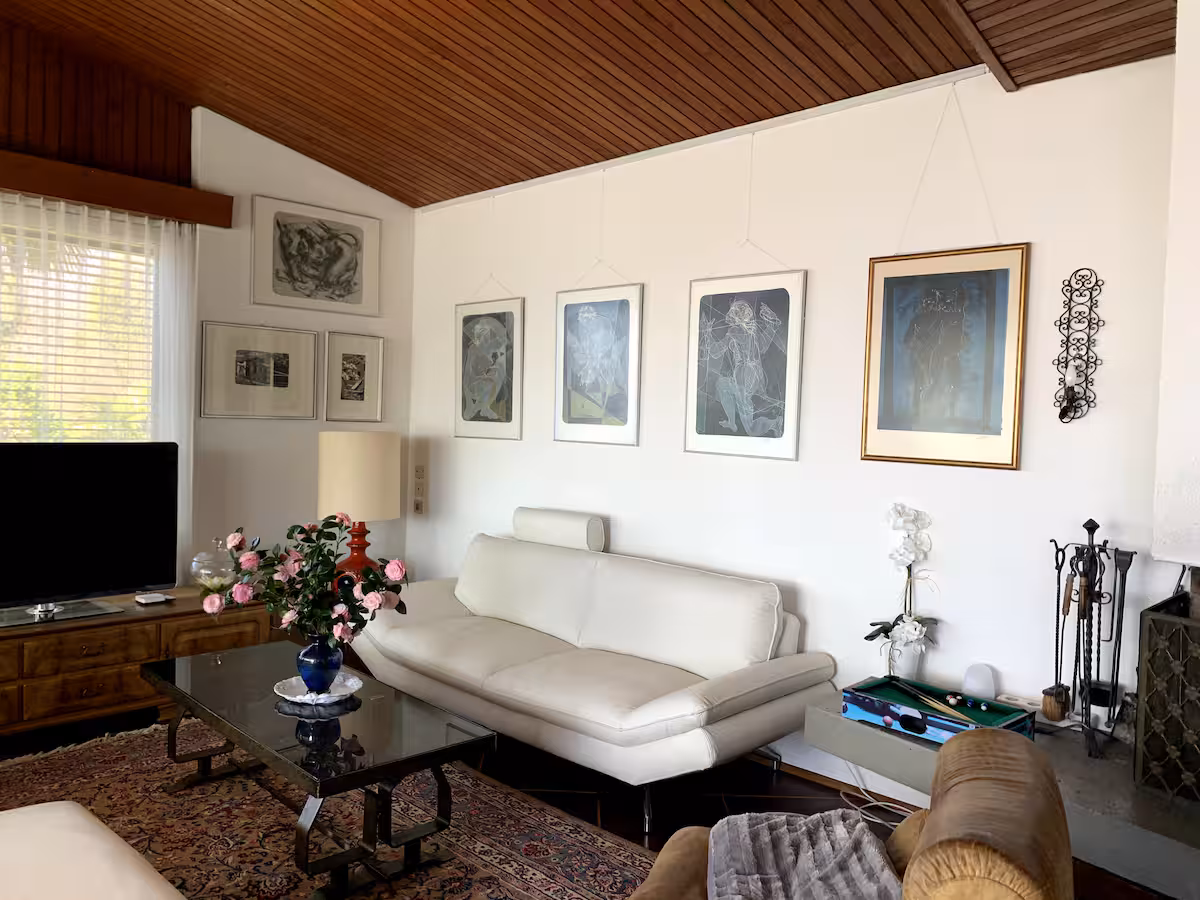 Salon de la villa avec canapé blanc, table basse et plafond en bois