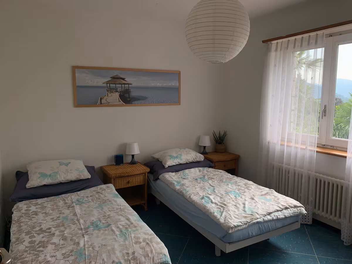 Chambre 2 de la villa Il Bell'Ovile : deux lits simples avec vue sur le jardin