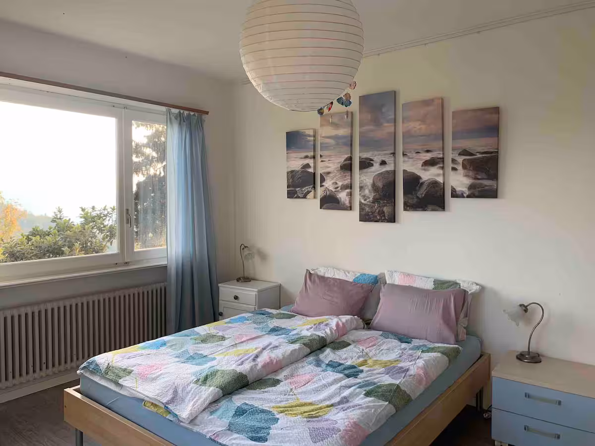 Chambre 1 de la villa Il Bell'Ovile : lit double, tableaux marins, rideaux bleus