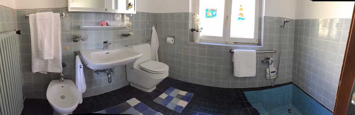 Salle de bain en grand angle avec baignoire et douche