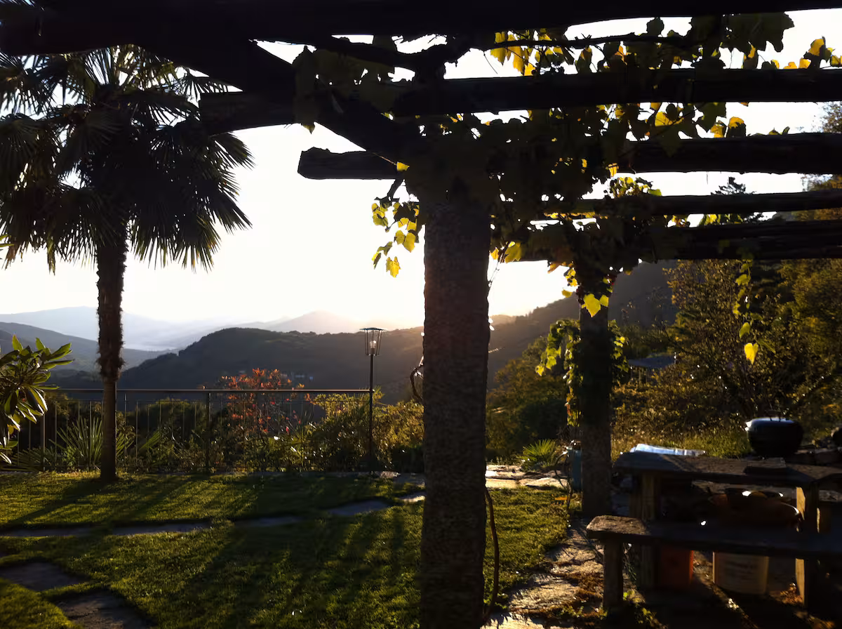 Jardin de la villa en fin de journée, pergola et collines au loin