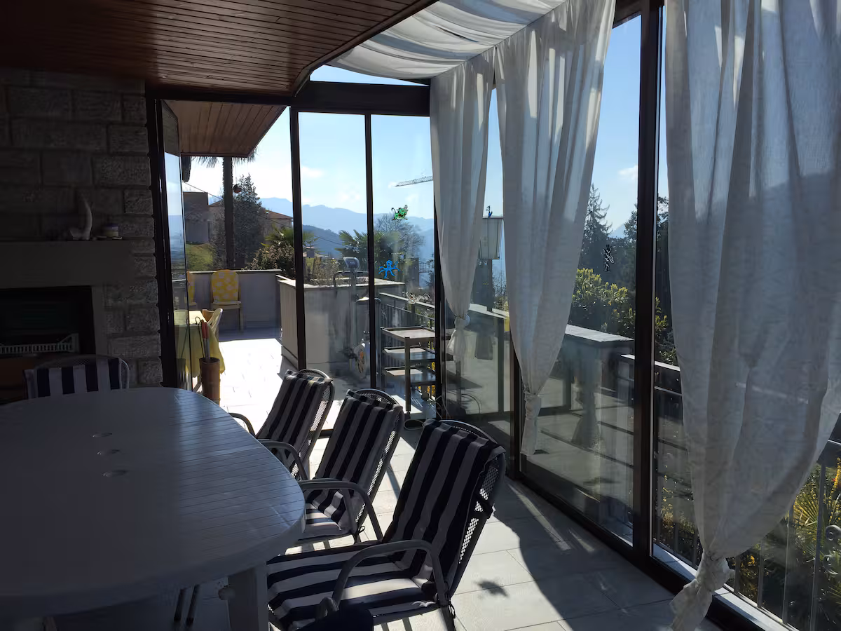 Terrasse couverte avec table et chaises, vue sur les montagnes